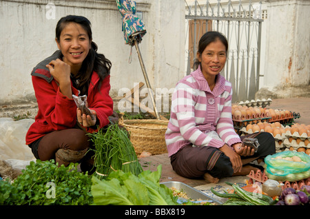 Deux femmes laotiennes de Luang Prabang stall les supports de marché alimentaire quotidien sourire pour la caméra Banque D'Images