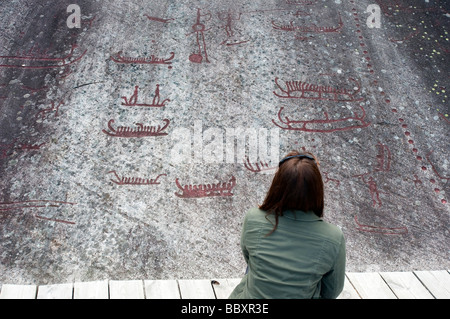 Woman looking at Bronze ancien à Vitlycke sculptures rupestres de Tanum sur avion en Suède Banque D'Images