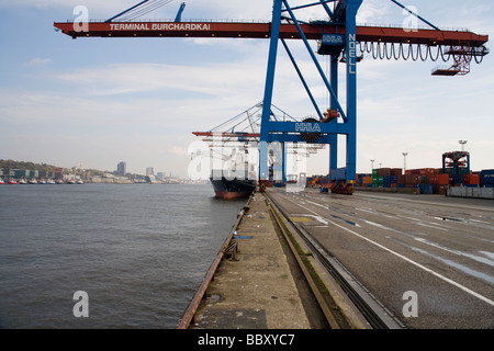 Un avis de grues Post-Panamax décharge des conteneurs dans un port européen. Banque D'Images