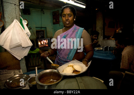 Restaurant d'une route près de Chennai, Inde. Le restaurant sert une cuisine simple, bonne nourriture de base. La femme sert les bras croisés. Banque D'Images