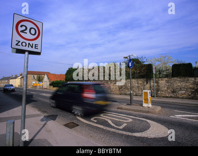 Une voiture passe 20 milles à l'heure de la zone de limite de vitesse panneau d'avertissement sur la route en passant par village près de Leeds yorkshire uk Banque D'Images