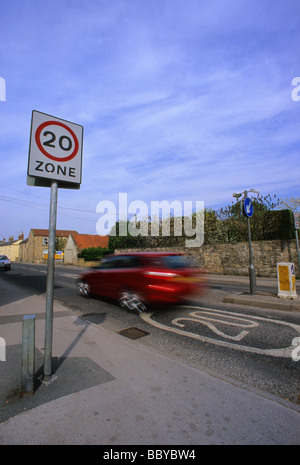 Une voiture passe 20 milles à l'heure de la zone de limite de vitesse panneau d'avertissement sur la route en passant par village près de Leeds yorkshire uk Banque D'Images