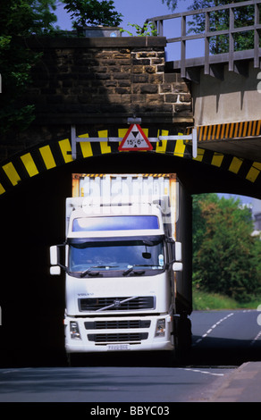 Camion passant sous faible pont de chemin de fer près de Leeds Yorkshire UK Banque D'Images