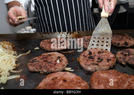 Chef des hamburgers sur un grill de cuisson à vendre à un événement public le comté de Down en Irlande du Nord uk Banque D'Images