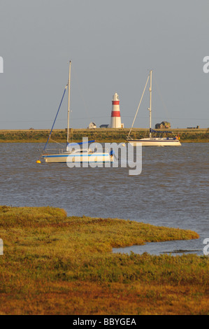 Voiliers amarrés sur River Ore et Phare en arrière-plan à Orford Suffolk Banque D'Images