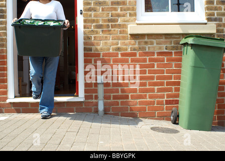 Woman putting out fort du recyclage Banque D'Images