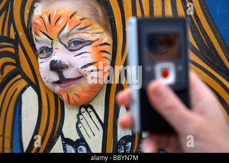 Jeune fille de cinq ans face à l'avoir peint photo prise par sa mère avec un téléphone mobile au Royaume-Uni Banque D'Images