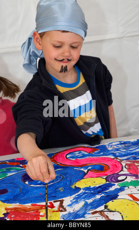 Young boy wearing fancy dress costume pirate une peinture murale Banque D'Images