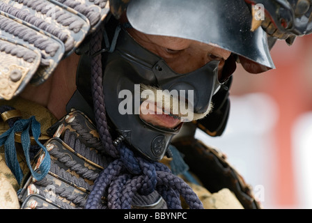 Homme en armure de samurai plein complet avec kabuto et mempo casque masque de visage pour intimider l'ennemi Banque D'Images