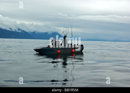 Pêcheur d'hommes jouant un saumon chinook dans open Océan Pacifique à Freeman Rocks contre fond de l'île Graham Haida Gwaii Banque D'Images