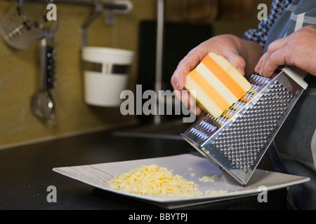 Mains de femme, 67 ans, grincement de fromage dans la cuisine Banque D'Images