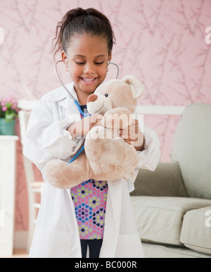 African girl playing doctor avec ours Banque D'Images