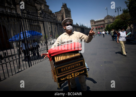 Un orgue de barbarie porte un masque par mesure de précaution contre la grippe porcine dans le Zocalo, la place principale de la ville de Mexico. Banque D'Images