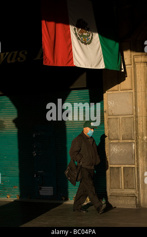 Un homme porte un masque par mesure de précaution contre la grippe porcine dans le Zocalo, la place principale de Mexico City Banque D'Images