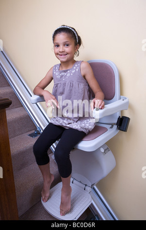 Une jeune fille a de grands sourires tout en jouant sur son grand grandad's-escalier Banque D'Images