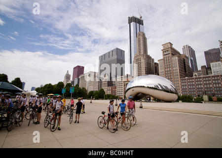 Les cyclistes dans le Millennium Park Chicago Illinois avec Anish Kapoor's Cloud Gate Sculpture aussi connu sous le nom de Bean. Banque D'Images