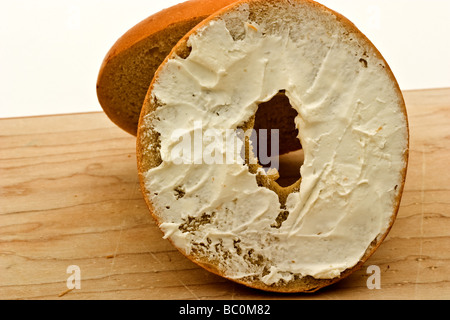 Bagel avec fromage à la crème sur une planche à découper Banque D'Images