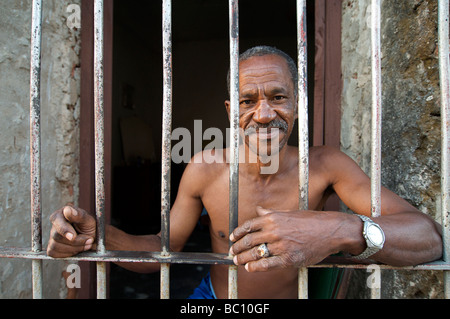 Cubain sympathique homme assis dans l'embrasure de la porte de sa maison, Trinnidad, CUBA. Parution du modèle objet Banque D'Images