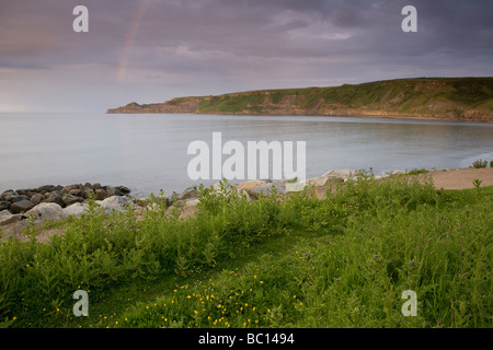 Un arc-en-ciel sur les falaises à Runswick Bay sur la côte du Yorkshire du nord au coucher du soleil Banque D'Images