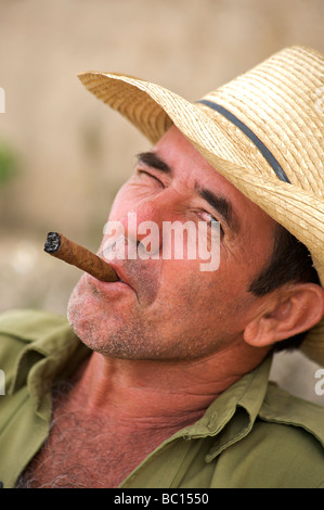 Bienvenus dans l'homme cubain et chapeau distinctif de fumer un cigare cubain avec un clin. Viñales, Pinar del Rio, Cuba. Banque D'Images