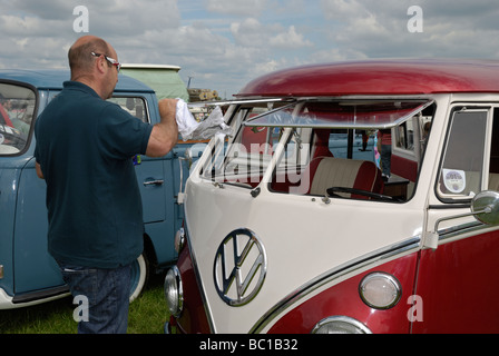 Un homme à polir ses camping-car VW split screen. Wymeswold, Leicestershire, Angleterre. Banque D'Images