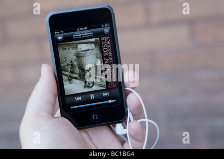 Un homme l'écoute d'un MP3 sur un Apple Ipod Touch. Banque D'Images