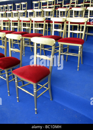 Des rangées de chaises d'or rouge pour les vip à un défilé en plein air event Banque D'Images