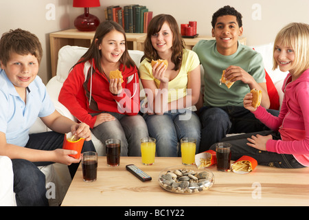 Groupe d'enfants de manger des hamburgers à la maison Banque D'Images