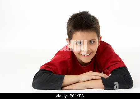 Young Boy Lying On Stomach In Studio Banque D'Images