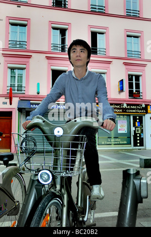 Paris France, scène de rue jeune homme asiatique vélo, vélo gratuit 'Velib' extérieur PORTRAIT DE GUY SUR LA rue Paris dans la journée Banque D'Images