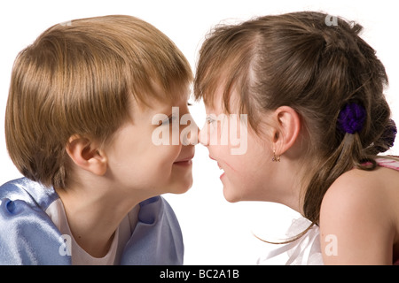 Deux petites filles s'assoient face à face et sourire isolated on white Banque D'Images