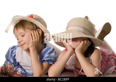 Deux petites filles se coucher sur le plancher se détourna isolated on white Banque D'Images