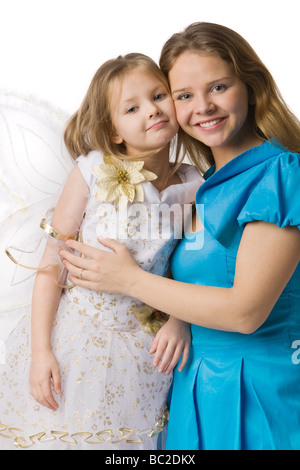 Jeune maman de belle robe fille embrasse en blanc tenue de fête avec les ailes de papillon isolated on white Banque D'Images