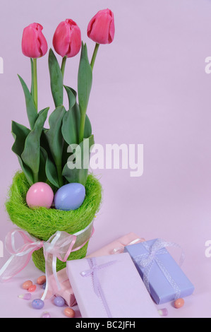 Les tulipes et les oeufs de Pâques avec des cadeaux et des bonbons Banque D'Images