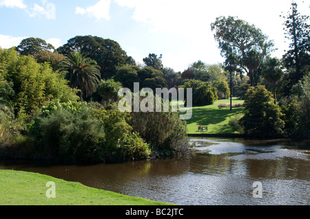 Personne assise sur un banc avec vue sur un lac à Royal Botanic Gardens, Melbourne, Victoria, Australie Banque D'Images