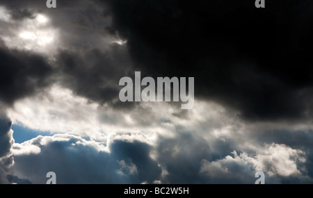 La formation de dark thunder storm clouds avec un patch de la lumière du soleil qui brillait à travers Banque D'Images