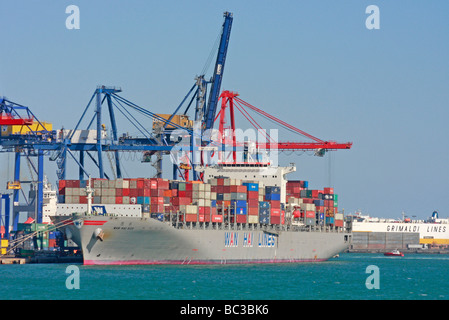 Cargo taïwanais haute empilée avec des conteneurs de marchandises asiatiques et de la marchandise déchargement dans le port de Gênes Méditerranée Banque D'Images