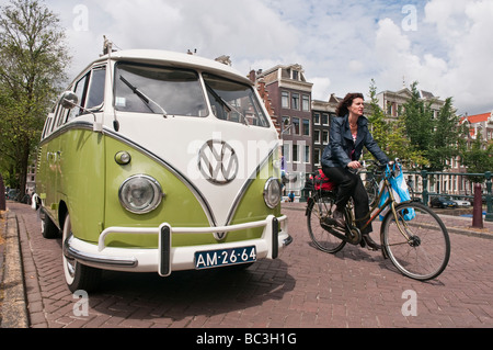 Camping-car Volkswagen garée sur un pont sur le canal Prinsengracht à Amsterdam, en tant que femme cyclist rides passé Banque D'Images