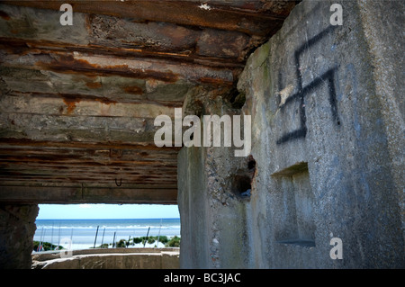 WW2 Historique canon allemand de béton et d'un belvédère bunker avec croix gammée surplombant graffiti les plages de Fort-Mahon Plage France Banque D'Images