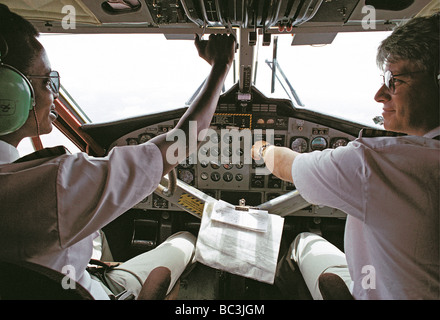 Le capitaine de l'Afrique noire et blanche caucasian co pilote à commandes d'un avion Twin Otter au Kenya Afrique de l'Est Banque D'Images