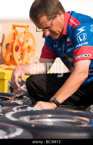 Un membre d'une équipe de course, aide à préparer les pneus de la voiture de son équipe avant le début de l'Indianapolis 500 2009. Banque D'Images