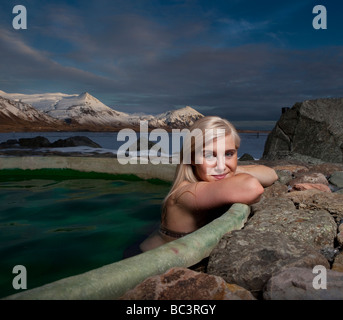 Jeune femme au bain à remous, chauffage géothermique Hornafjordur, l'Est de l'Islande Banque D'Images