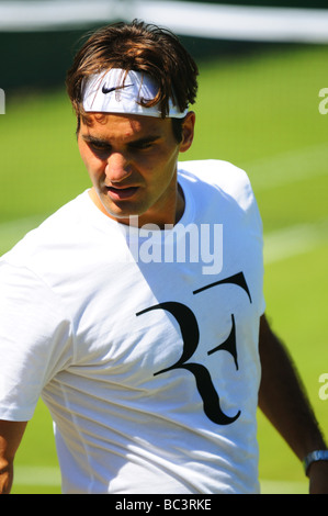 Le suisse Roger Federer joue avec Sam Querry sur une pratique du tribunal pendant le tournoi de Wimbledon 2009 Banque D'Images