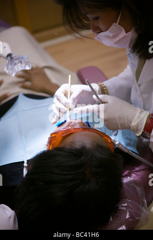 African American Woman de couleur visite le dentiste pour obtenir ses dents blanchies dans une tentative de transformer moderne de son sourire d'un cran. Banque D'Images