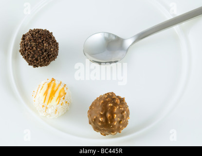 Trois truffes organisé sur cuillères à café on white plate Banque D'Images