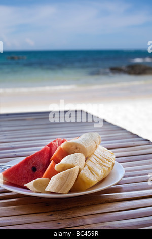 Salade de fruits sur une table en bois bleu de la mer en arrière-plan Selective focus Banque D'Images