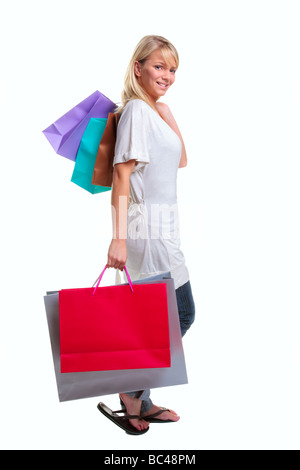 Blonde woman carrying shopping bags colorés isolé sur fond blanc Banque D'Images