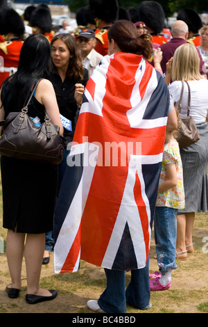 Une femme enveloppée dans le drapeau de l'Union britannique on armed forces day à Londres. Banque D'Images