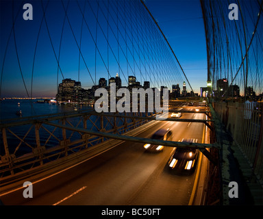 Voitures traversant le pont de Brooklyn de nuit Banque D'Images