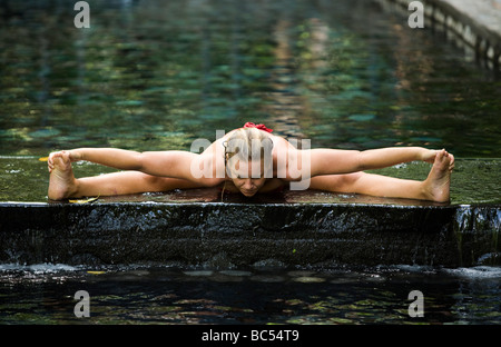 Une femme prend une pose de yoga dans une source thermale et spa ou des bains thermaux dans La Fortuna, Costa Rica près de Arenal Banque D'Images